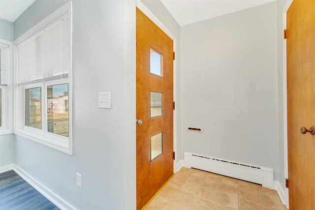 hall featuring tile patterned floors, baseboard heating, and baseboards