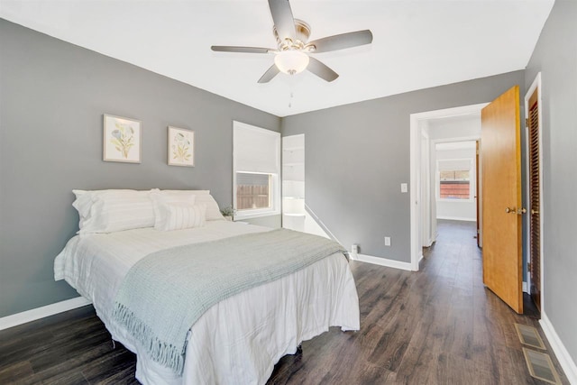 bedroom with visible vents, baseboards, dark wood-type flooring, and a ceiling fan