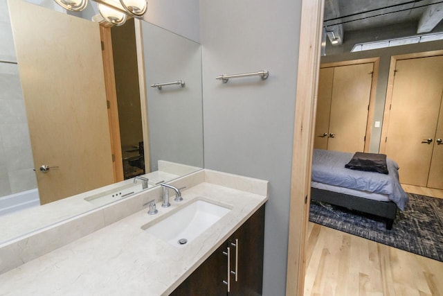 ensuite bathroom with vanity, wood finished floors, and ensuite bathroom