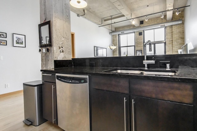 kitchen featuring light wood-type flooring, a sink, dark countertops, rail lighting, and dishwasher