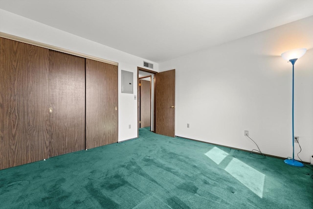 unfurnished bedroom with visible vents, electric panel, carpet, and a closet