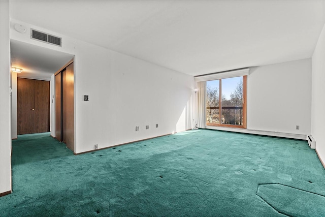 spare room featuring visible vents, carpet, and a baseboard radiator