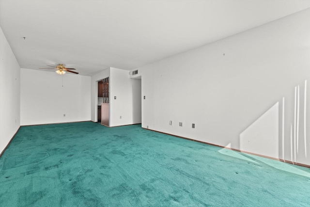 spare room with a ceiling fan, carpet, and visible vents