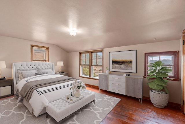 bedroom featuring dark wood-type flooring, baseboards, and vaulted ceiling