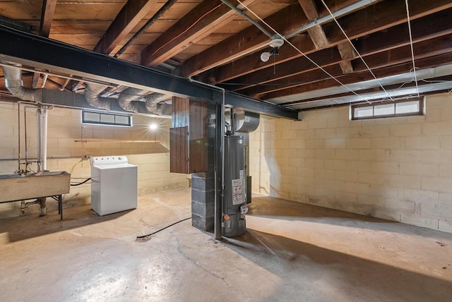 below grade area featuring a sink, washer / clothes dryer, and water heater