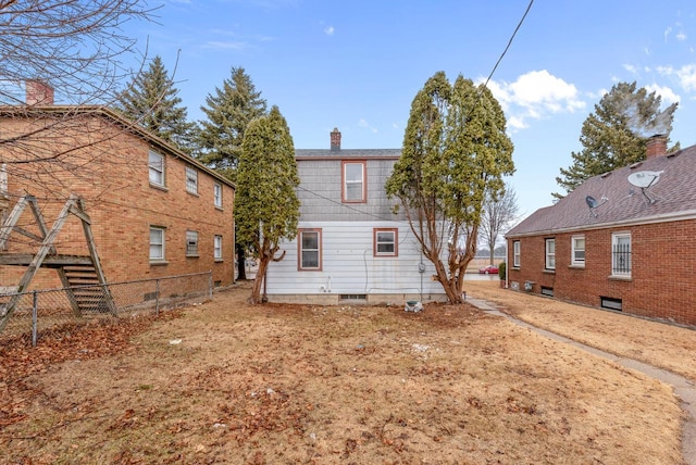 back of property featuring a chimney and fence