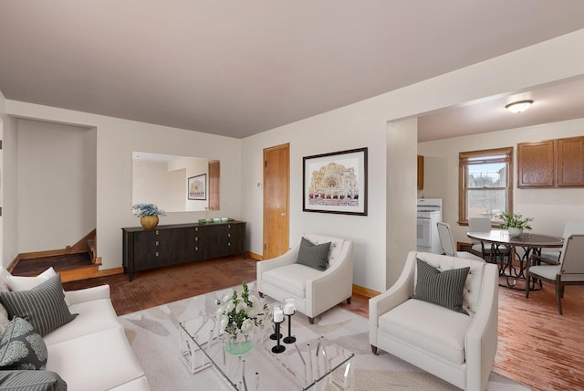 living area featuring stairway, light wood-style flooring, and baseboards