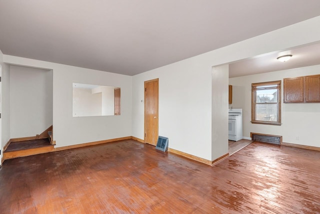 unfurnished living room featuring stairway, baseboards, and wood finished floors