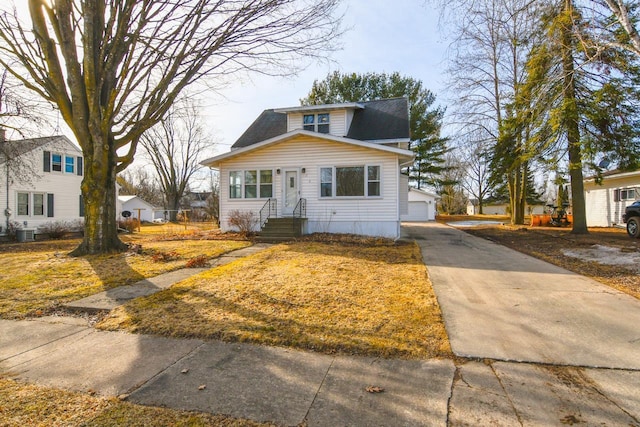 bungalow with entry steps, an outbuilding, cooling unit, and a garage