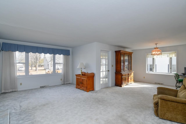 living area featuring an inviting chandelier, carpet flooring, and visible vents