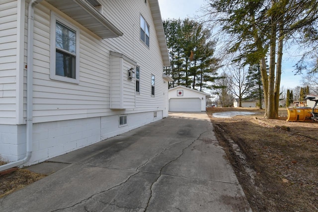 view of property exterior with an outbuilding and a detached garage