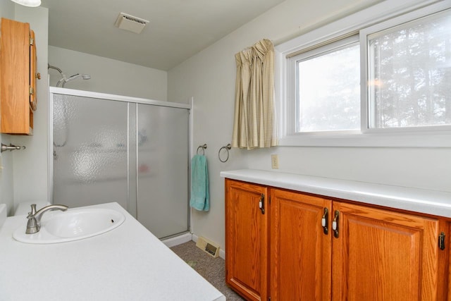 bathroom with vanity, visible vents, and a stall shower