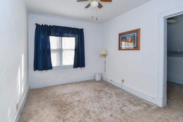 carpeted empty room with baseboards and ceiling fan