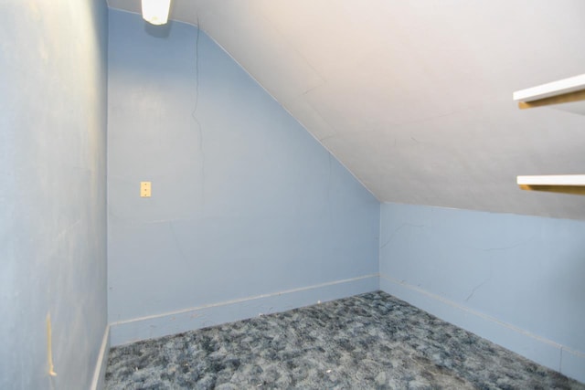 bonus room with baseboards, lofted ceiling, and carpet