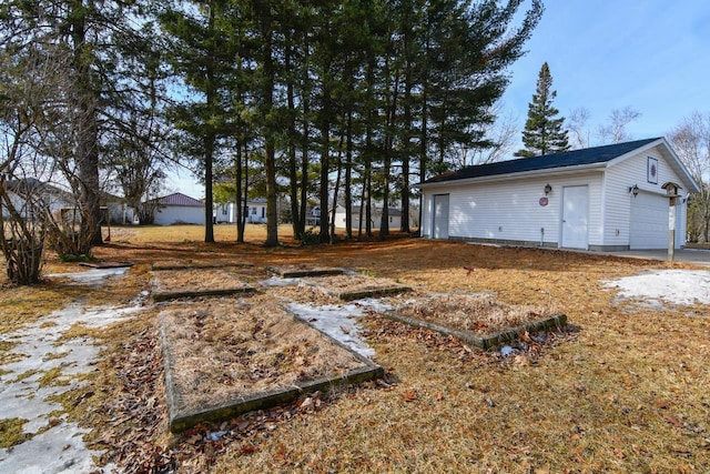 view of yard featuring a garage and an outdoor structure