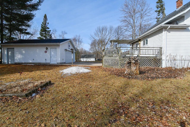 view of yard featuring an outbuilding, a garage, and a deck