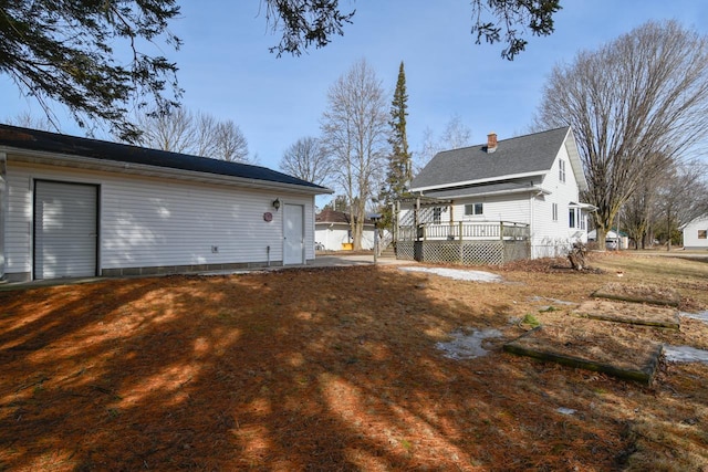 rear view of property featuring a chimney and a deck