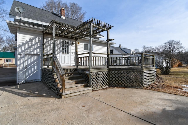 rear view of property with a wooden deck, a shingled roof, a chimney, and a pergola