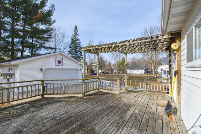 deck featuring an outdoor structure, a pergola, and a detached garage