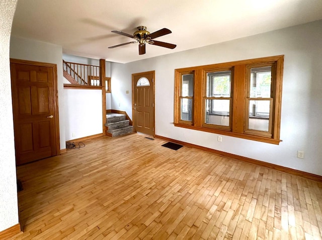 entryway featuring light wood finished floors, stairs, and baseboards