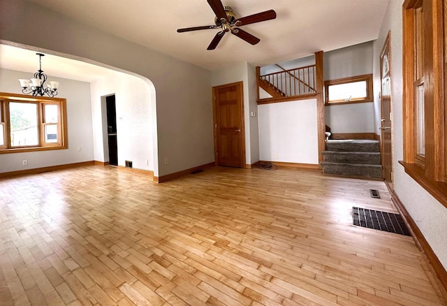 interior space featuring arched walkways, visible vents, stairway, and light wood-type flooring