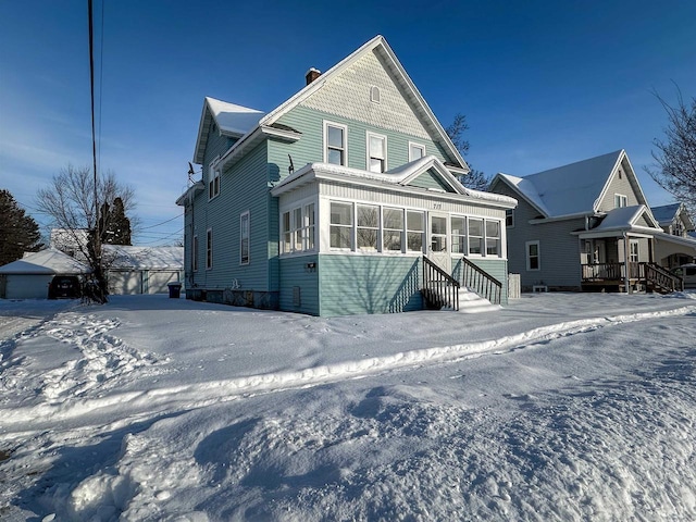 view of front of property with a sunroom and a chimney