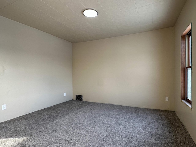 carpeted spare room featuring visible vents