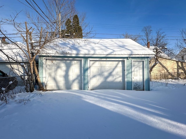 snow covered garage featuring a garage