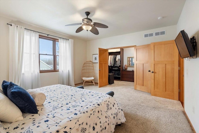 bedroom featuring a closet, visible vents, light colored carpet, and ceiling fan