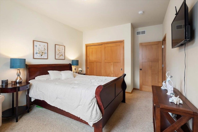 bedroom featuring visible vents, light colored carpet, and a closet