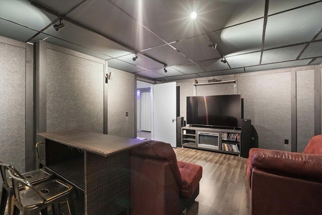 living area with track lighting and wood finished floors