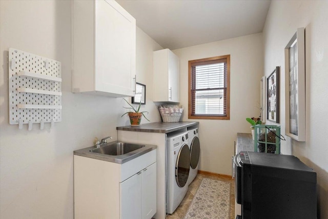 laundry room with a sink, baseboards, cabinet space, and independent washer and dryer