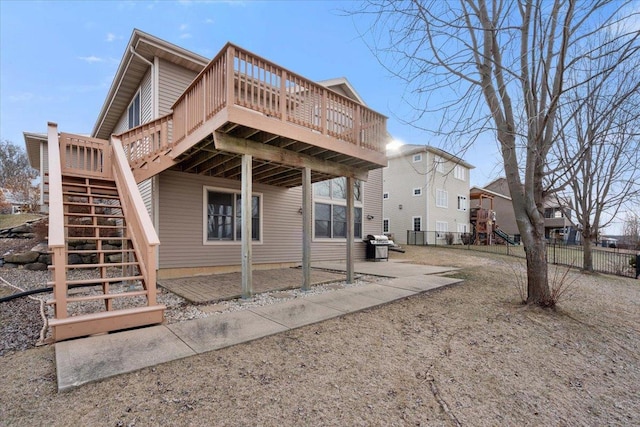 back of house with a deck, stairs, and fence