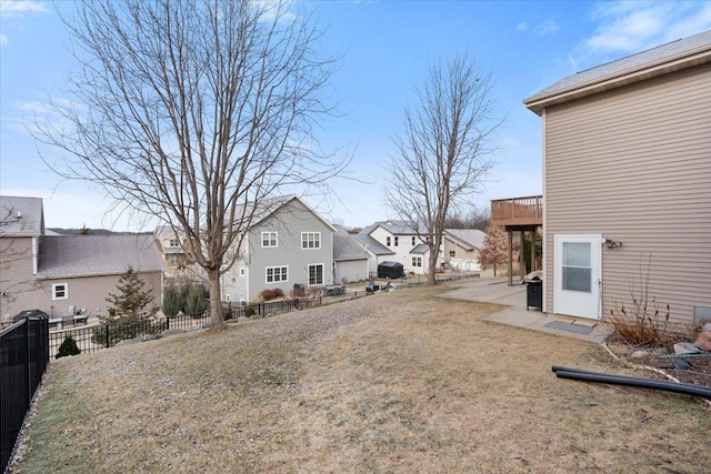 view of yard with a patio area, a fenced backyard, and a residential view