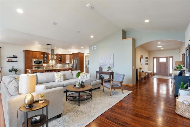 living area with visible vents, high vaulted ceiling, recessed lighting, arched walkways, and dark wood-style flooring