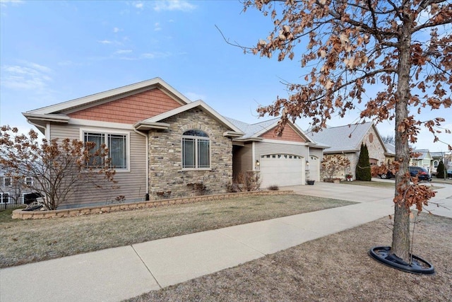 ranch-style house featuring concrete driveway, an attached garage, and stone siding