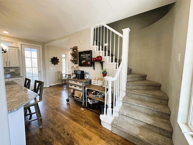 staircase featuring baseboards and wood finished floors