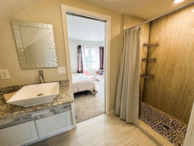 full bathroom featuring connected bathroom, vanity, and a tile shower