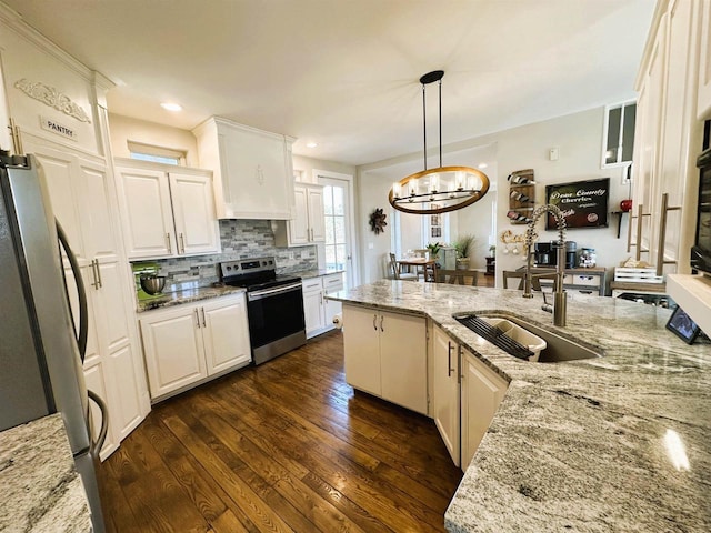 kitchen with tasteful backsplash, dark wood finished floors, a chandelier, appliances with stainless steel finishes, and a sink