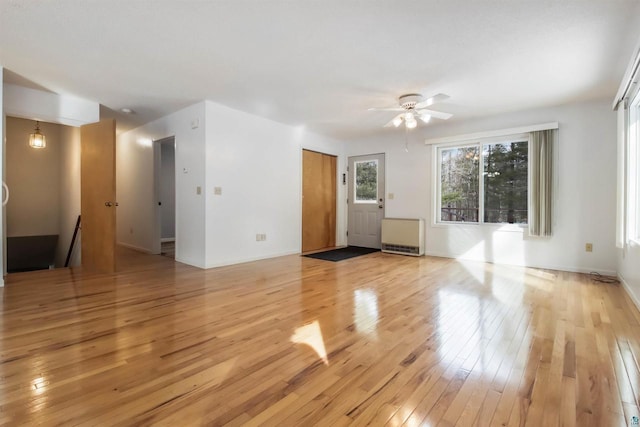 unfurnished living room with baseboards, light wood finished floors, and ceiling fan