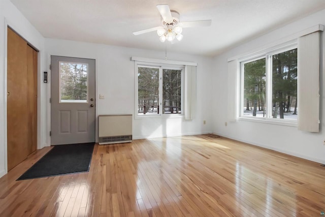 foyer entrance featuring radiator, light wood-type flooring, and a wealth of natural light