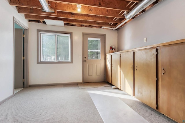 interior space featuring baseboards and light carpet