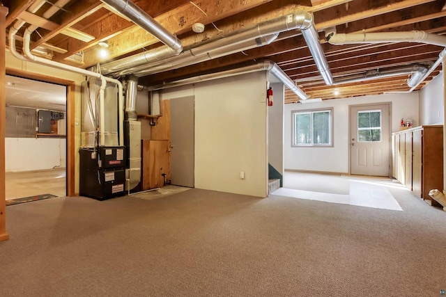 below grade area featuring electric panel, heating unit, and carpet floors