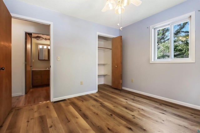 unfurnished bedroom featuring visible vents, wood finished floors, baseboards, and a closet