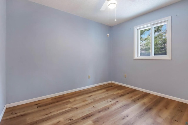 unfurnished room with ceiling fan, baseboards, and wood finished floors