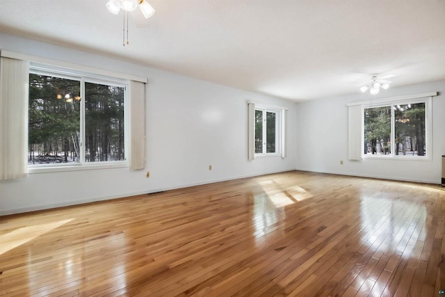 spare room featuring plenty of natural light, wood-type flooring, and ceiling fan