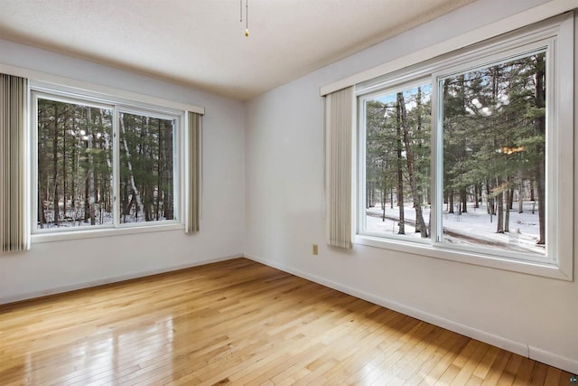 empty room with hardwood / wood-style flooring and baseboards