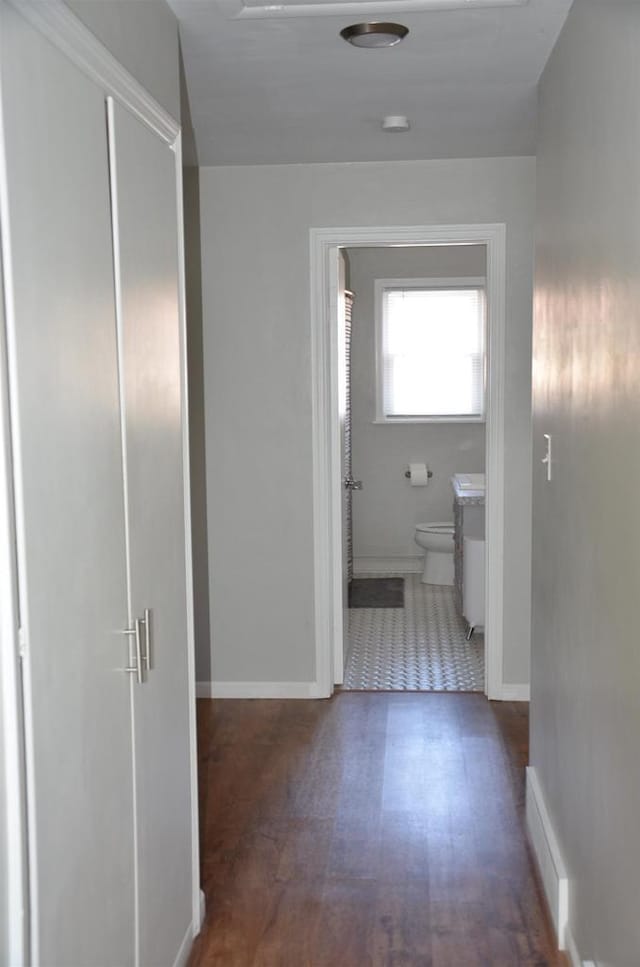 hallway with baseboards and wood finished floors