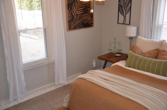 carpeted bedroom with baseboards, multiple windows, and baseboard heating