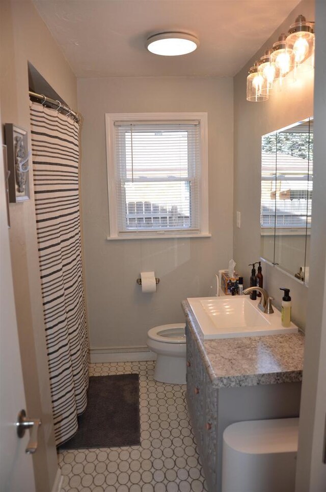 bathroom with vanity, toilet, and baseboards